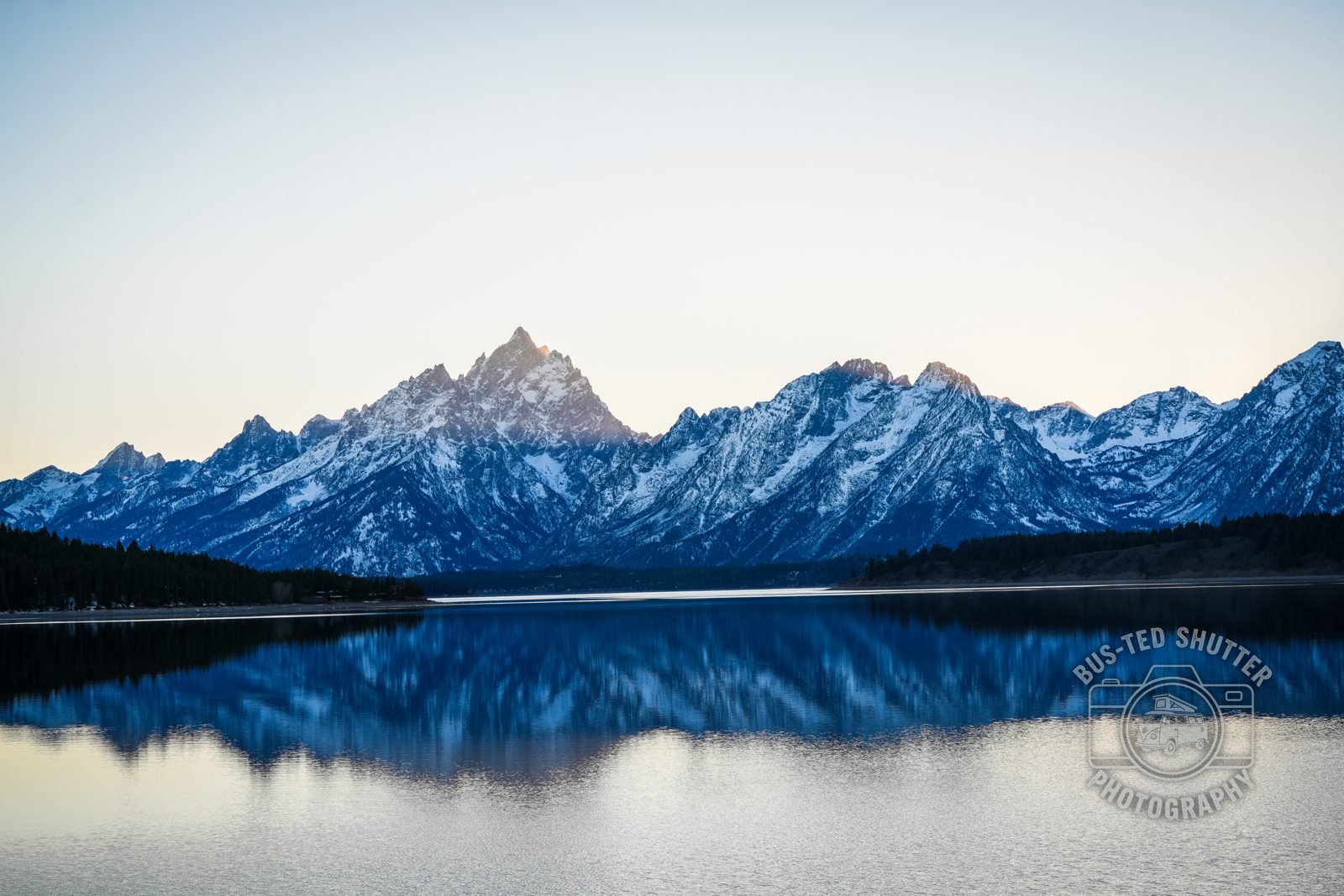 Grand Teton range mirrored in a still lake at dawn